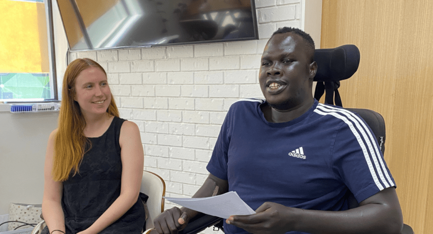 A woman interviewing a man in a wheelchair